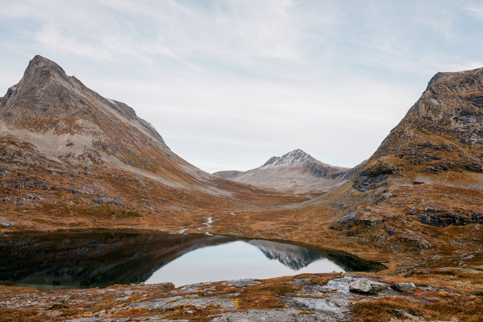 A still tarn on the Trollstigen plateau mirroring the peaks at the head of the pass