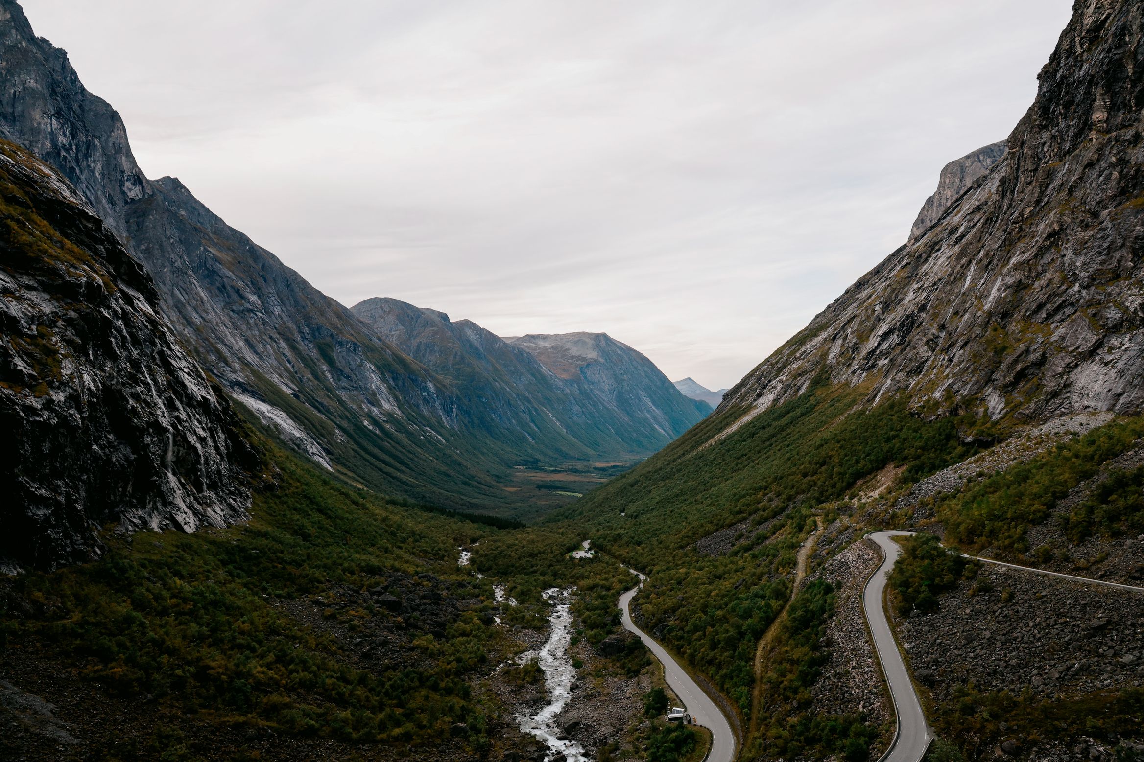 The Trollstigen road switchbacking down into Isterdalen, the river running white along the valley floor