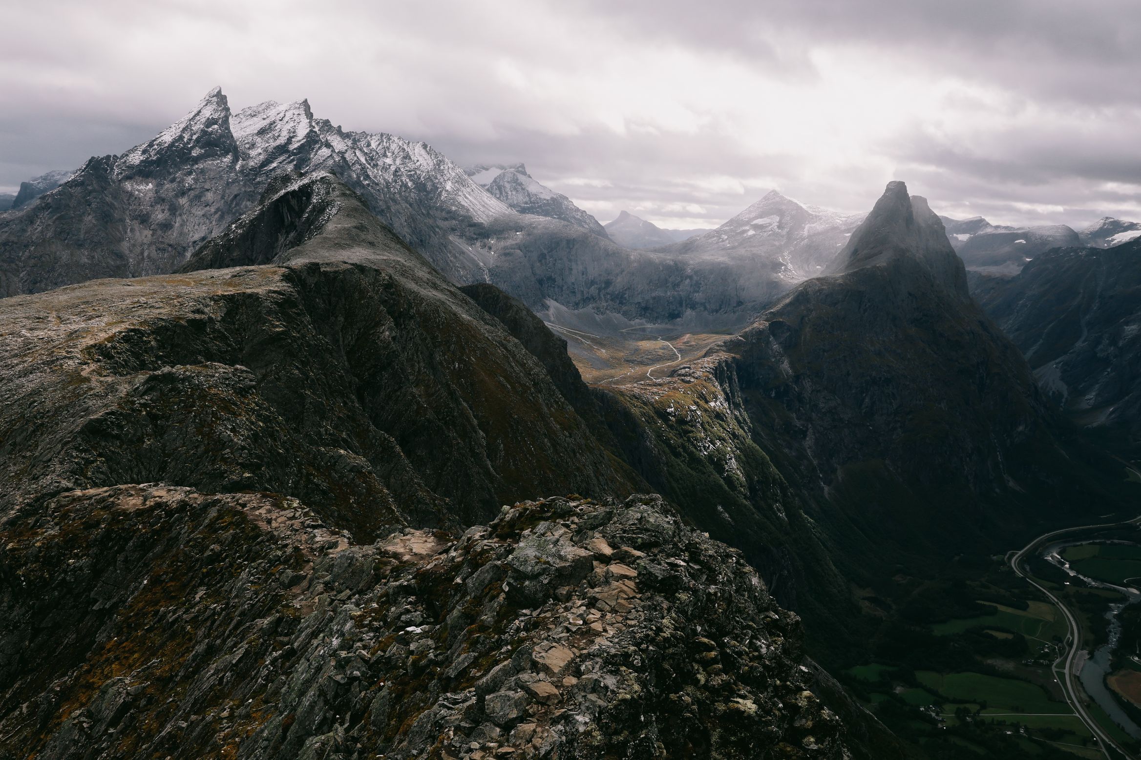 The Romsdalseggen ridge running out between peaks, the valley road visible far below on the right