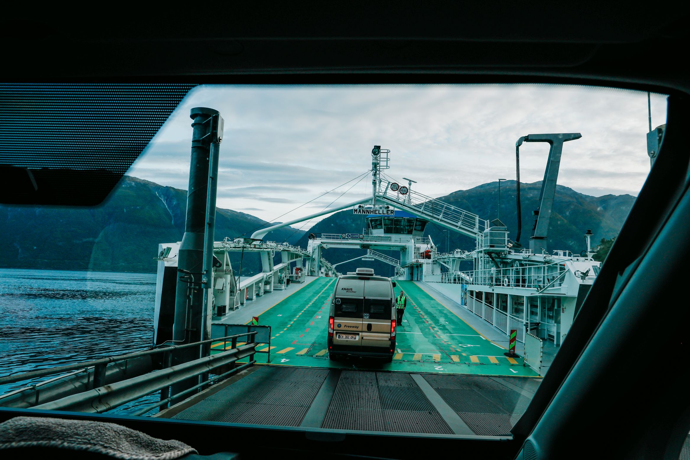 Through the windscreen on a ferry, a camper van ahead on the green-painted deck