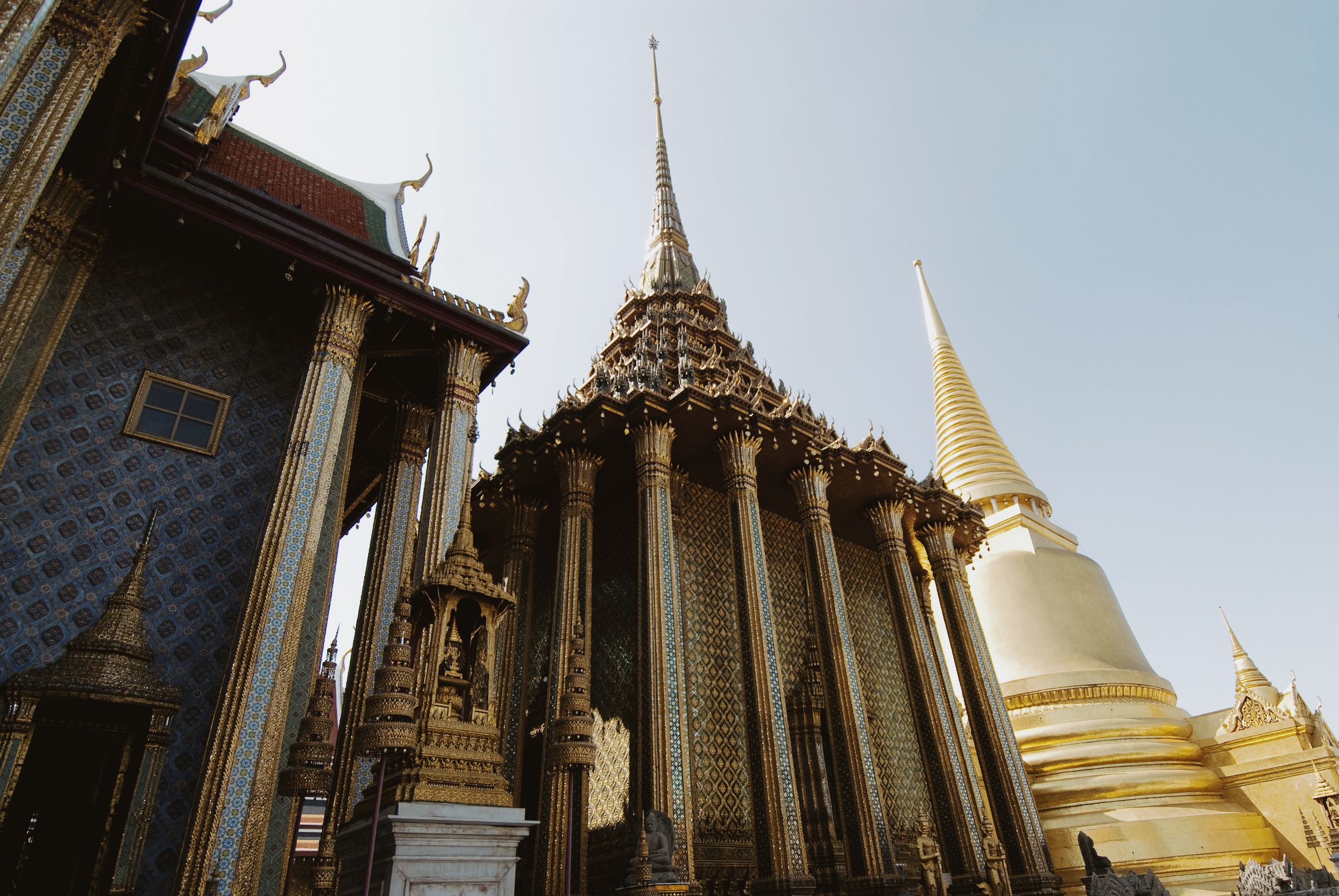Gilded spires and a golden chedi crowded together against a pale sky