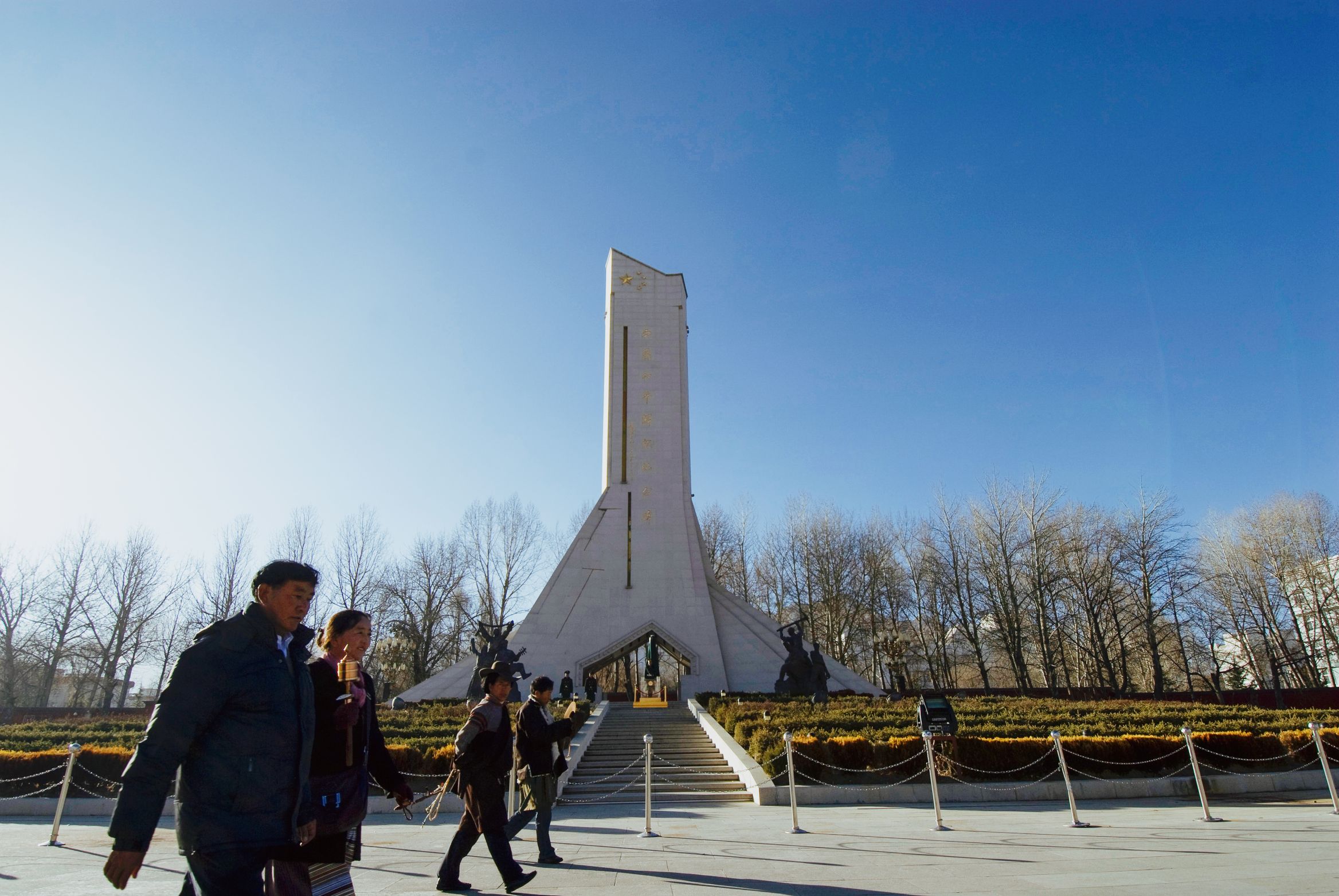 The Chinese monument raised on the square directly opposite, a competing spire staring back at anyone looking out from the palace, people walking past it into the low winter sun