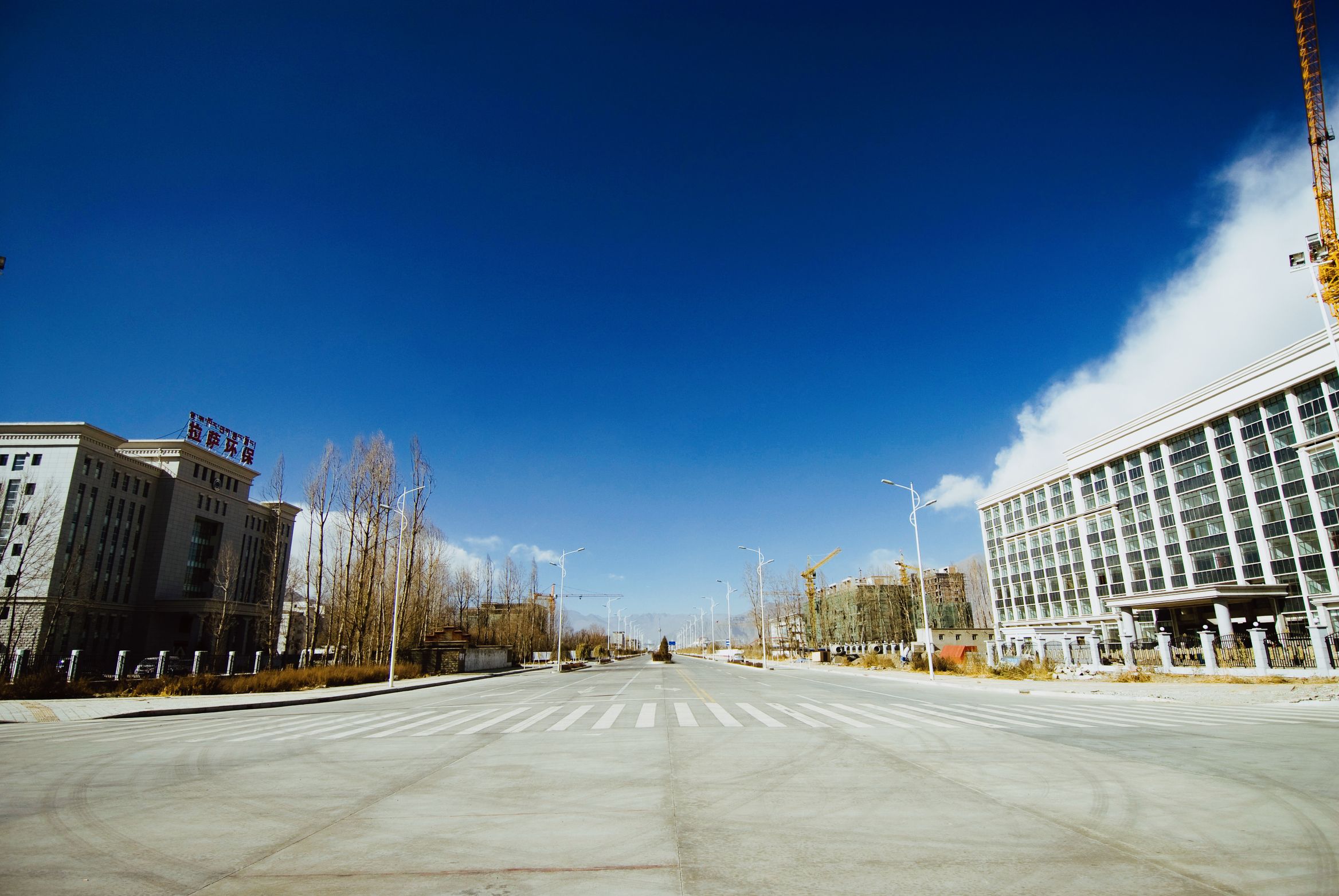 A brand new six-lane road running empty between office blocks on the edge of town